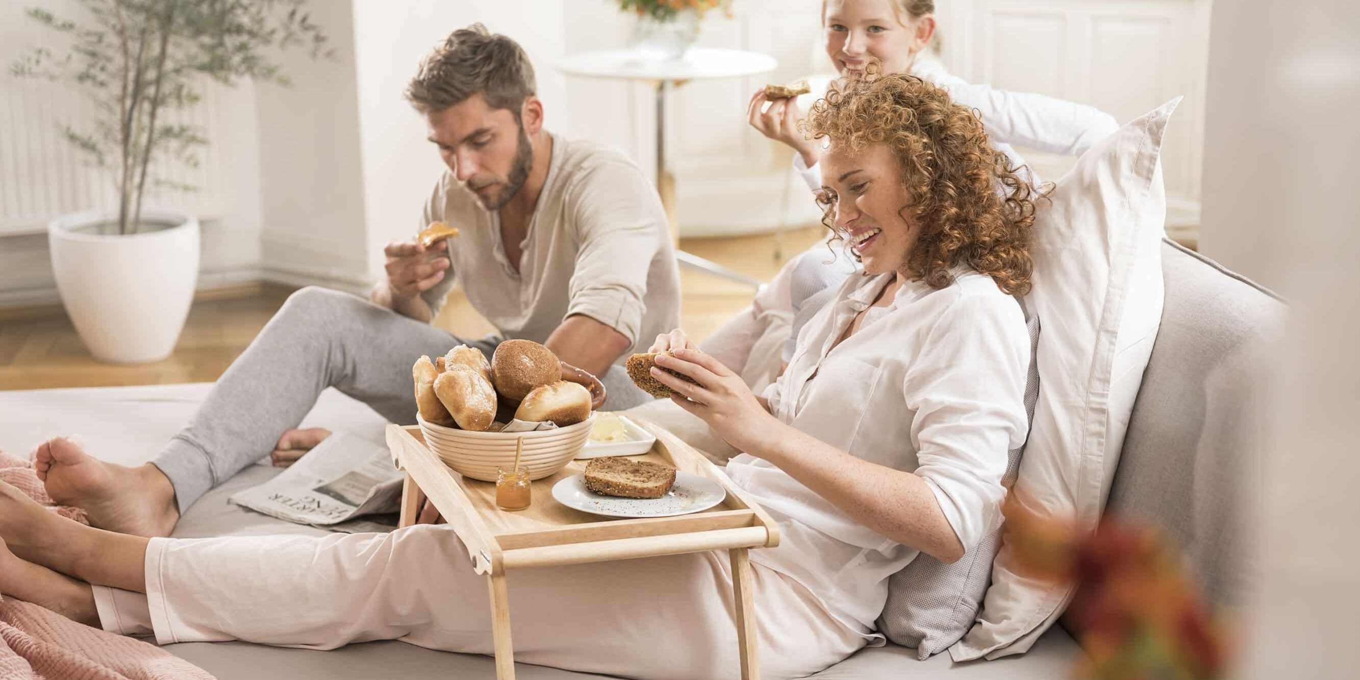 Familie auf dem Sofa am Frühtsücken