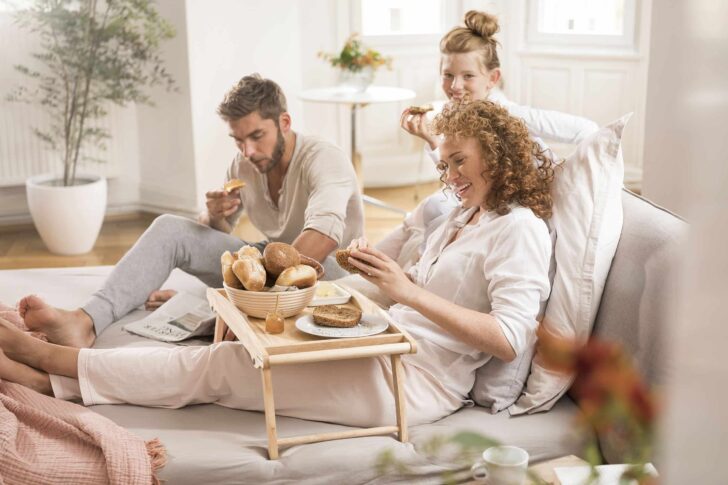 Familie auf dem Sofa am Frühtsücken