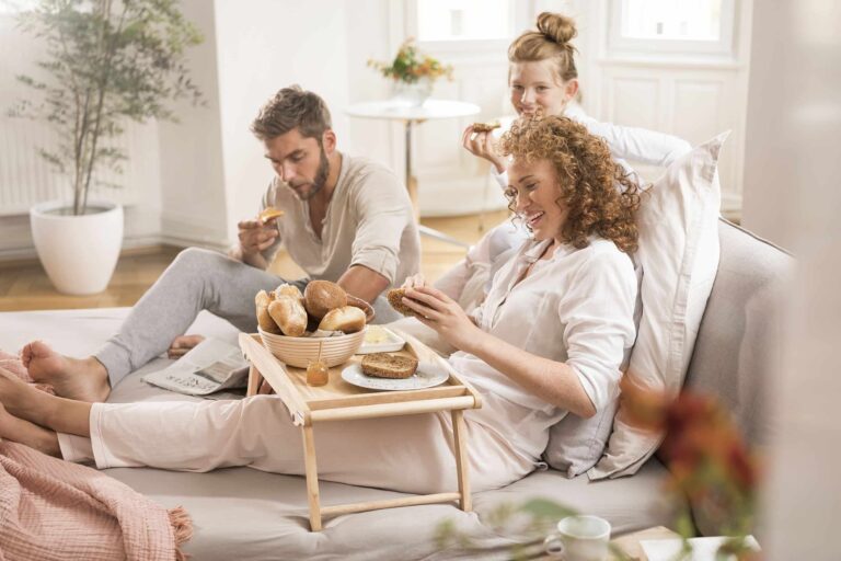 Familie auf dem Sofa am Frühtsücken